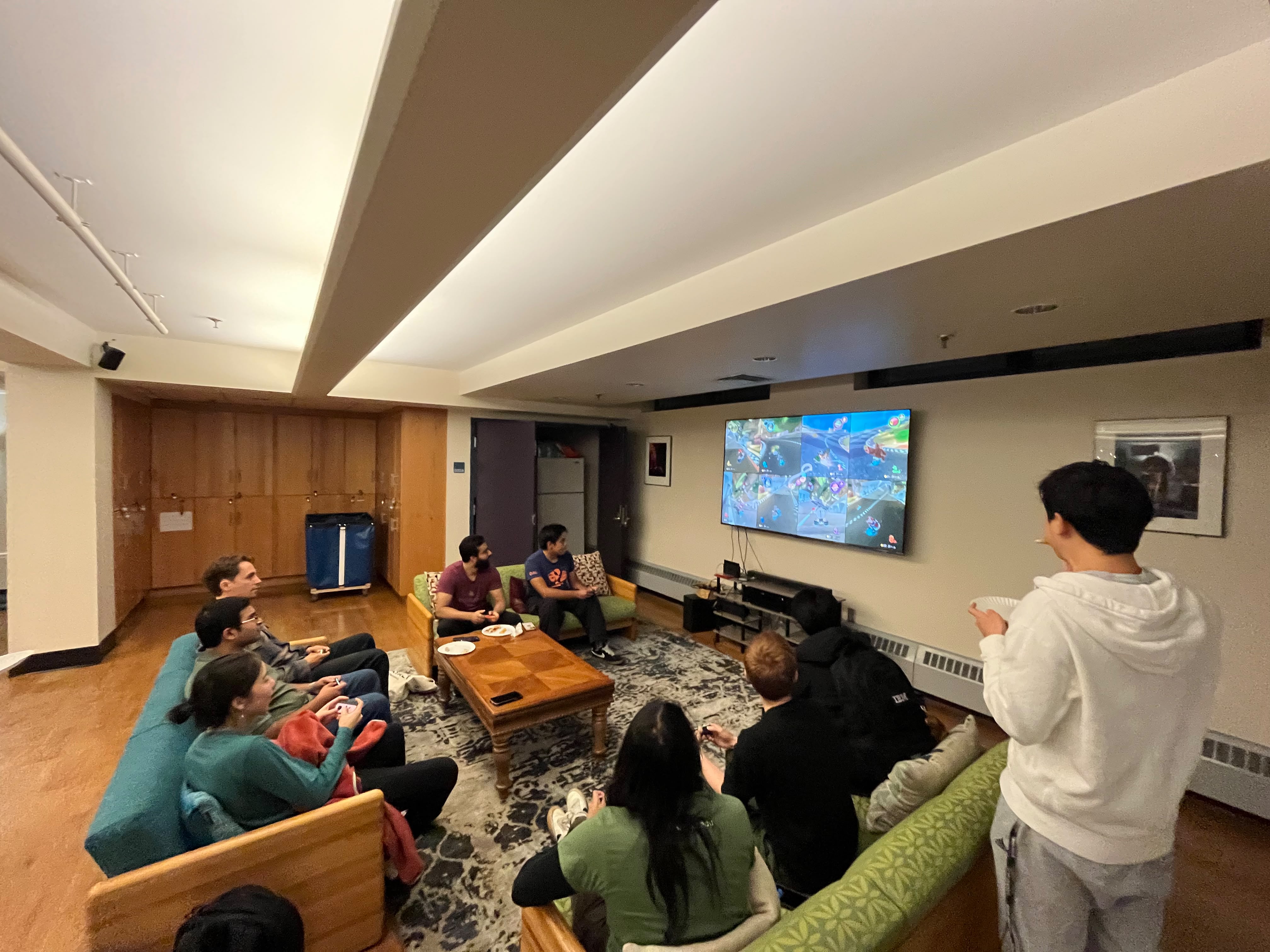 Residents watching and playing Mario Kart on a large screen in the Edgerton Large Lounge