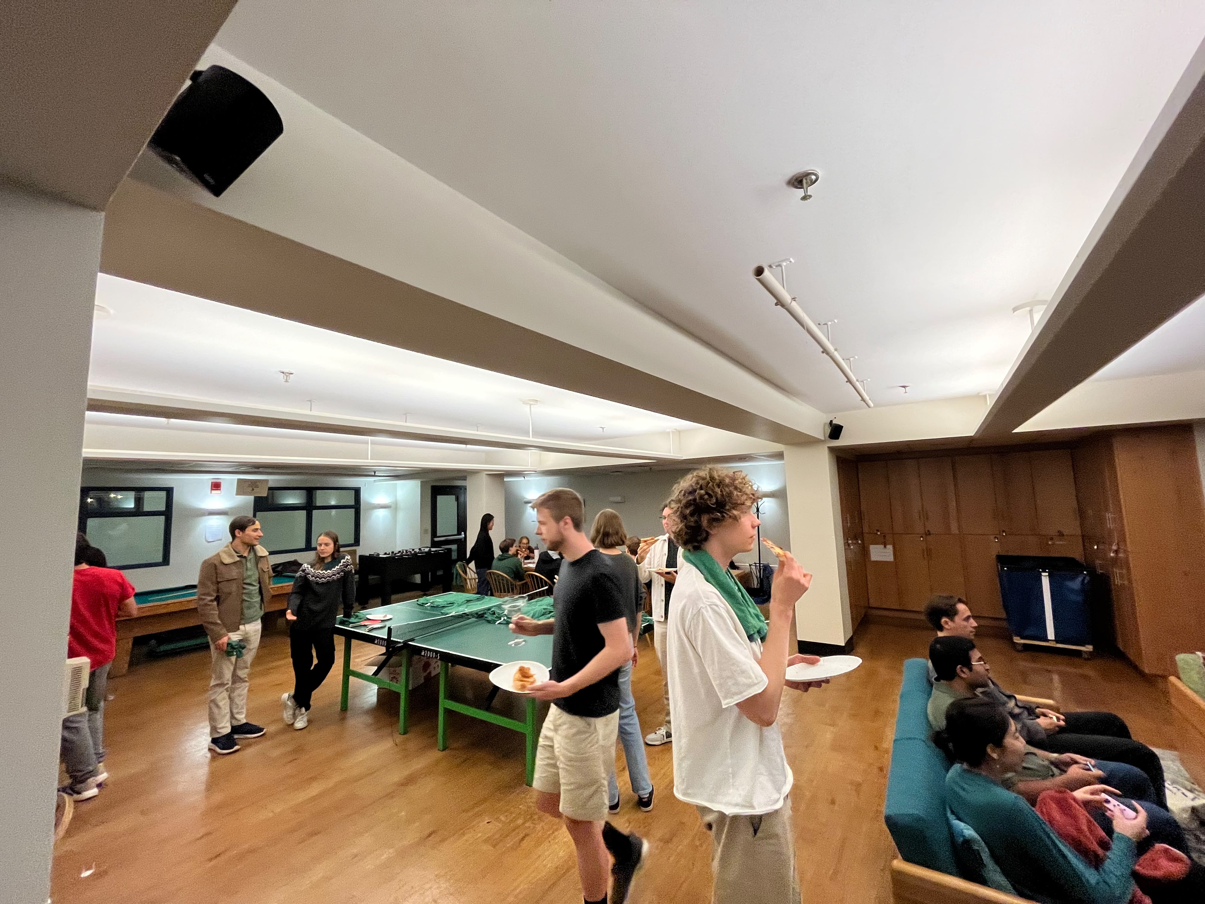 Residents sharing pizza and playing ping-pong at the Edgerton game night