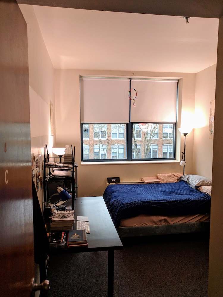 Furnished bedroom with bed, desk, and shelving